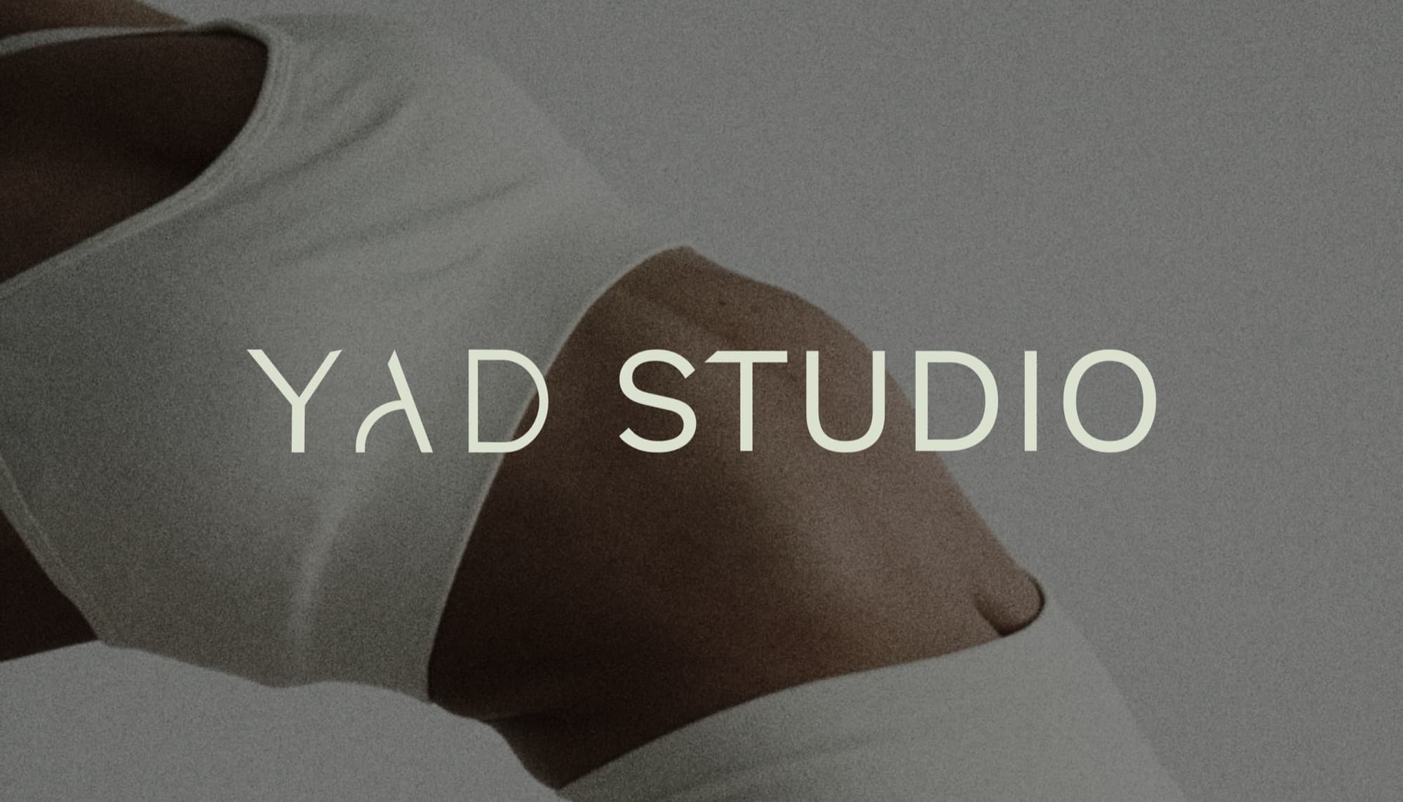 YAD Studio logotype set over a softly lit yoga pose.