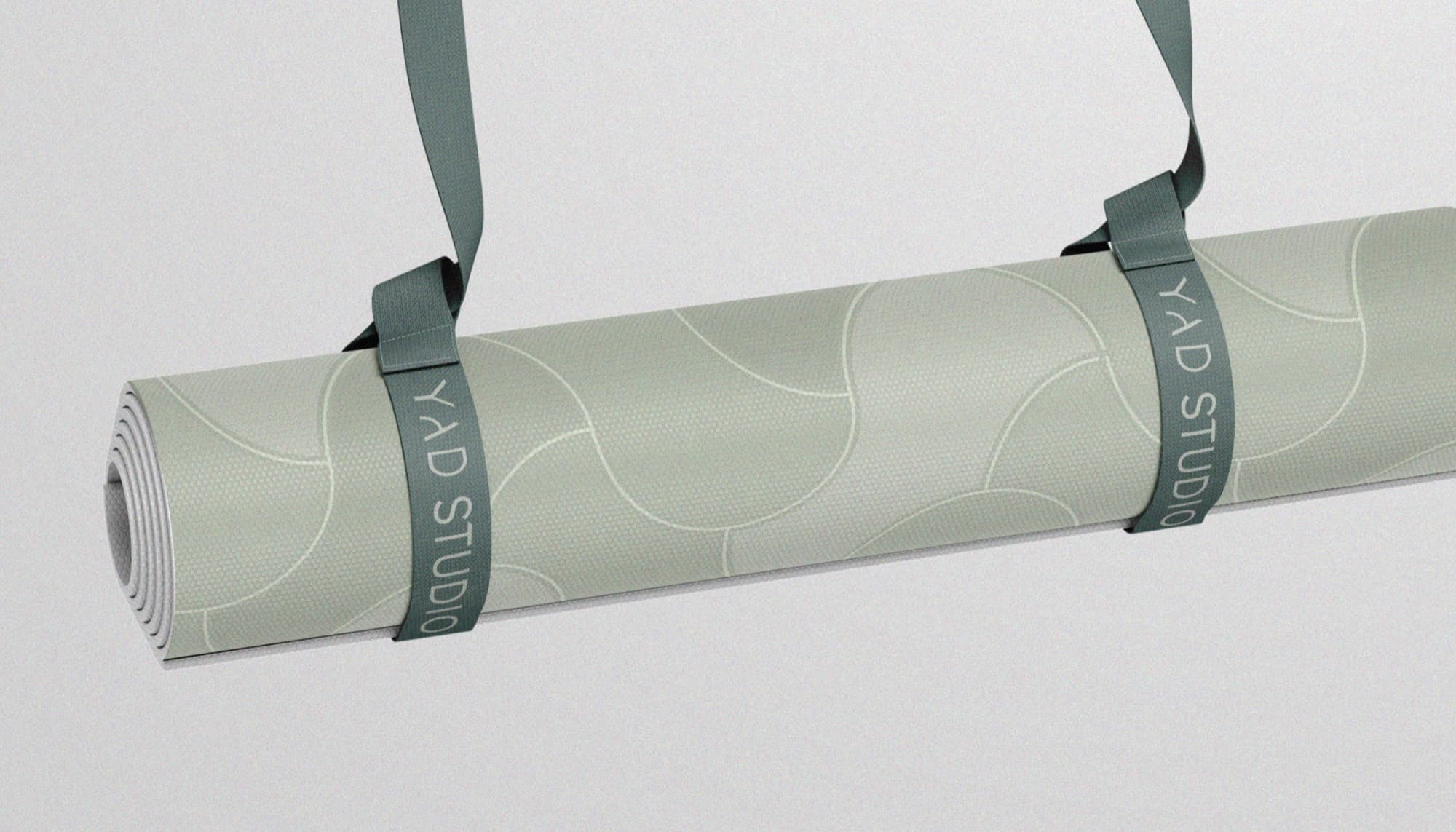 Rolled YAD Studio yoga mat with a carry strap.