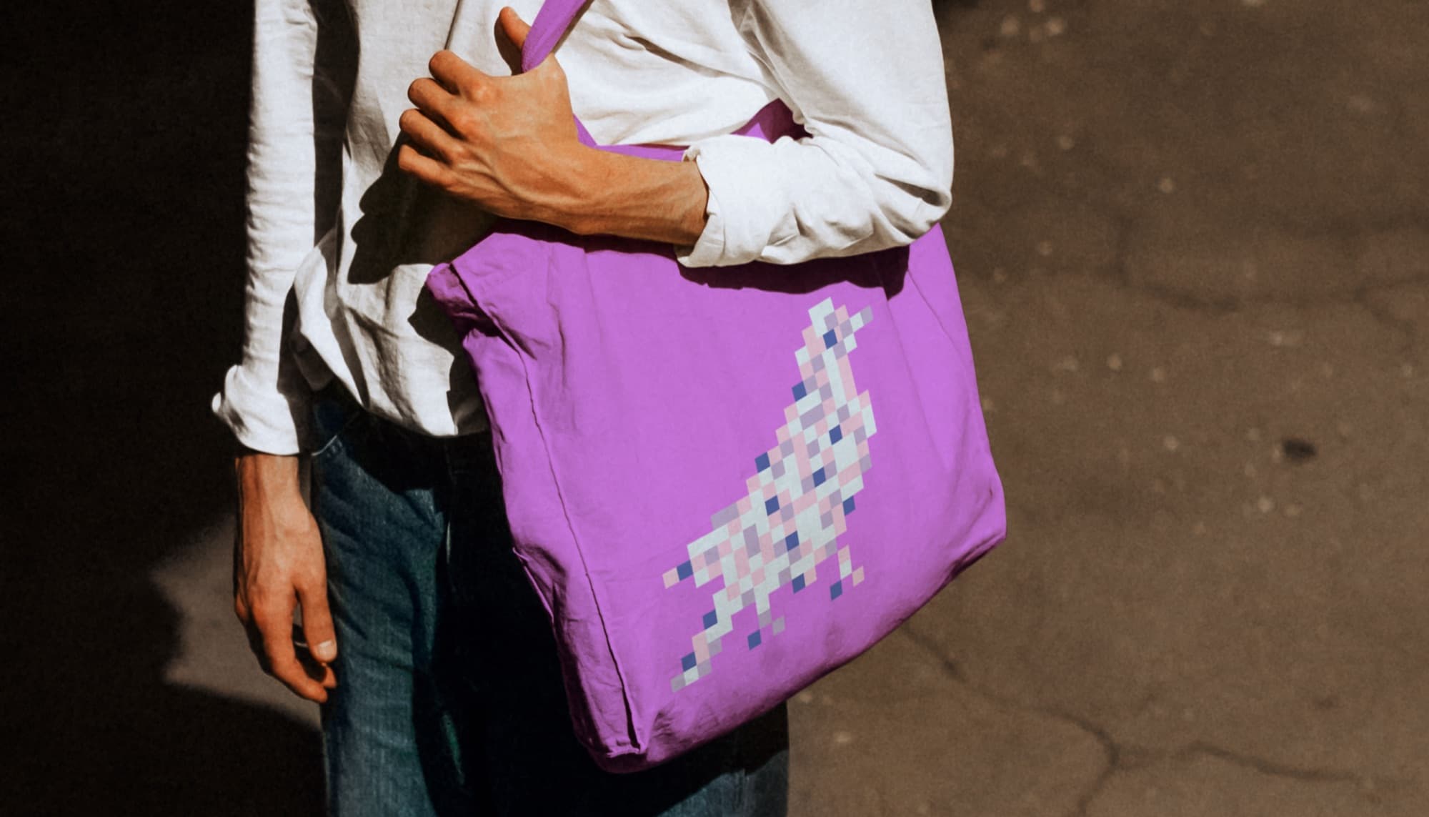 Person carrying a purple KUTR tote bag on the street.